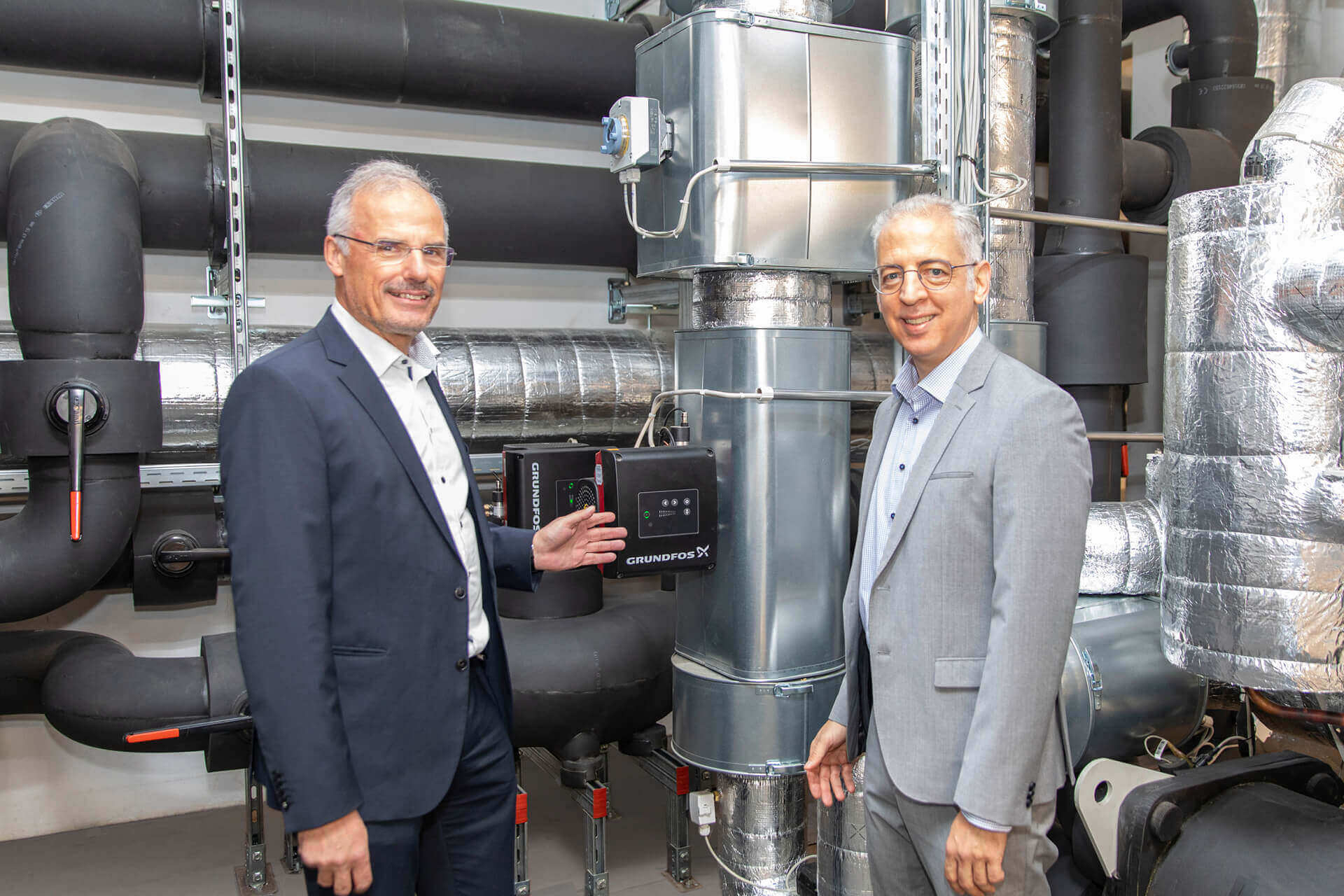 CFO Karl Tschacha (left) and Managing Shareholder Roland Schreiner of Schreiner Group are proud of the newly installed heat pumps. The principal of the pump house construction project was Schreiner Immobilien 1 GmbH & Co. KG. Hence the heat pump project was successfully executed under the responsibility of its CEO, Prof. h.c. mult. Dr. h.c. Ing. Helmut Schreiner.