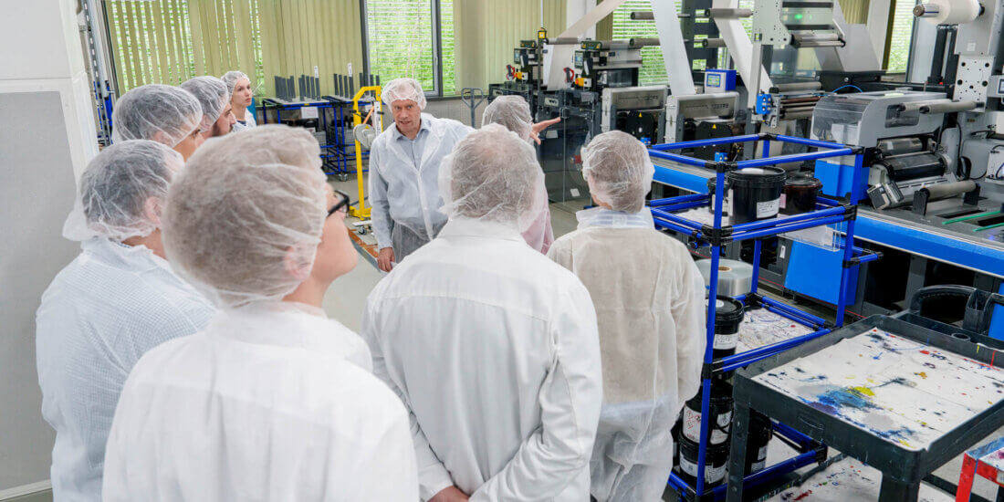 Connected for Sustainability Dr. Thomas Gulden takes the guests on a tour of Schreiner Group’s shop floor in Oberschleißheim.