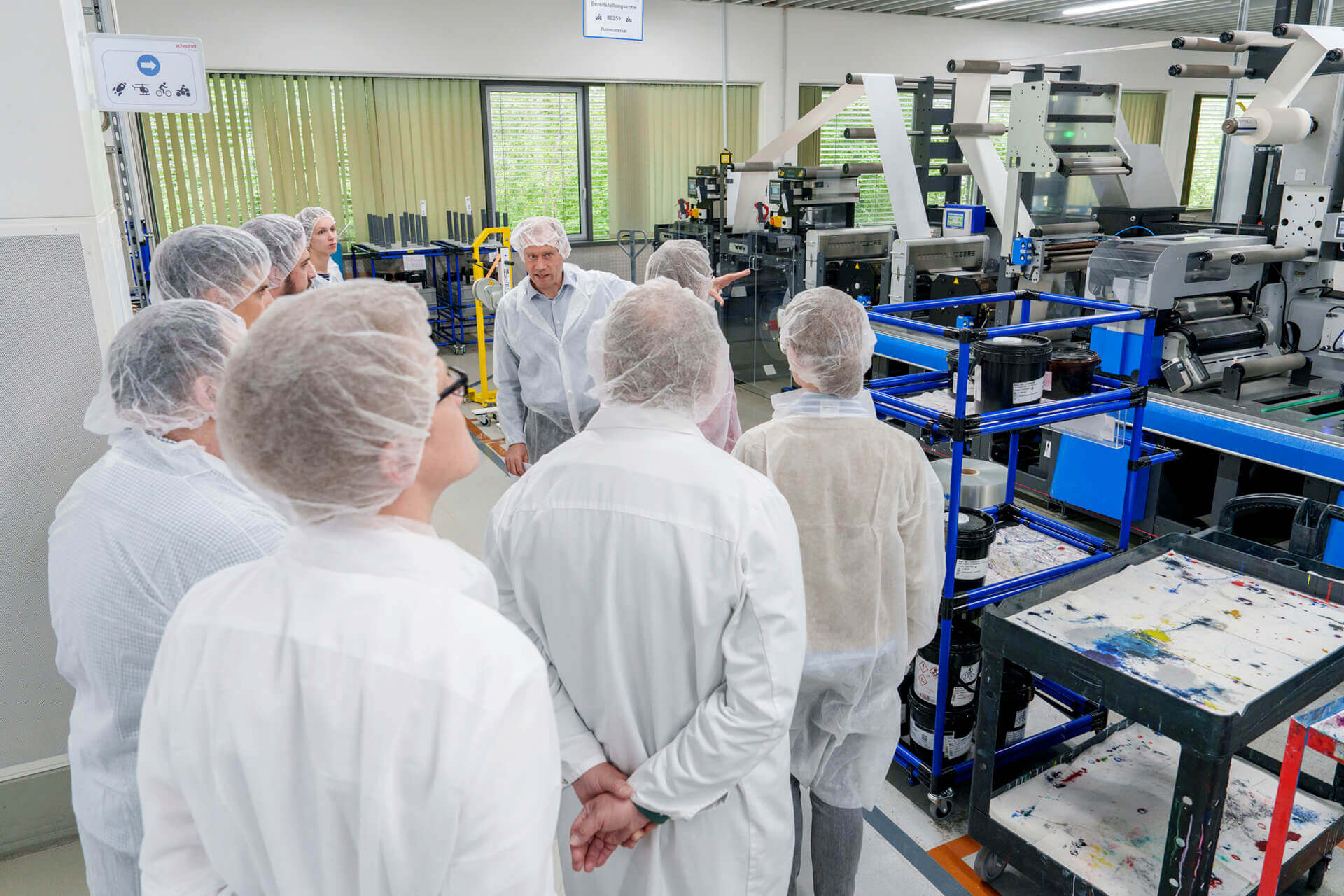 Dr. Thomas Gulden takes the guests on a tour of Schreiner Group’s shop floor in Oberschleißheim.